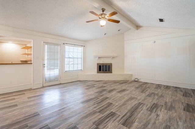 unfurnished living room with vaulted ceiling with beams, a textured ceiling, a fireplace, and wood finished floors