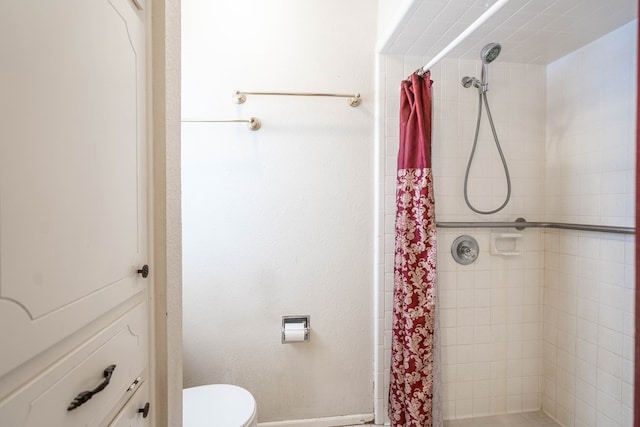 bathroom featuring toilet and a shower stall