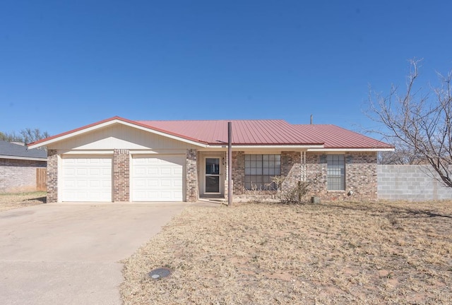 single story home featuring a garage, concrete driveway, brick siding, and metal roof