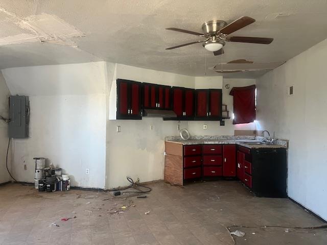 2508 22nd St, Snyder, TX 79549 - kitchen featuring a ceiling fan, electric panel, under cabinet range hood, a sink, and dark brown cabinets