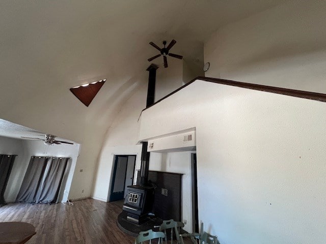 2508 22nd St, Snyder, TX 79549 - living area with high vaulted ceiling, a wood stove, a ceiling fan, and wood finished floors
