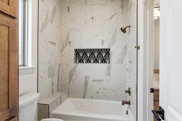 bathroom featuring toilet and tiled shower / bath