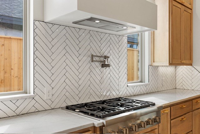 kitchen with a wealth of natural light, tasteful backsplash, and stainless steel gas stovetop