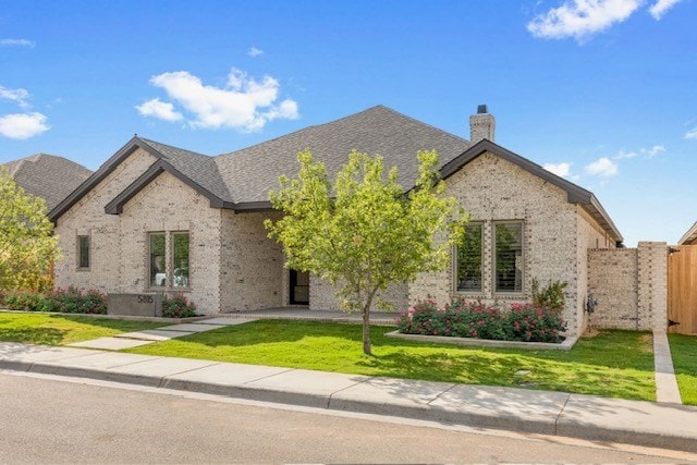 french country inspired facade featuring a front lawn