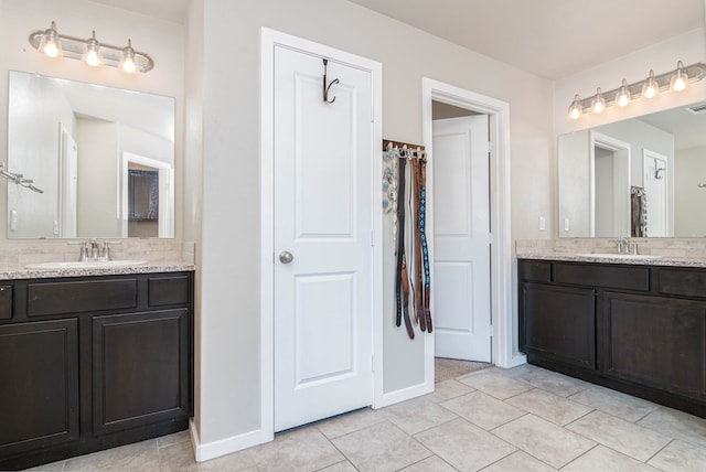 1407 Derrick Ave, Odessa, TX 79765 - full bath featuring two vanities, tile patterned flooring, baseboards, and tasteful backsplash