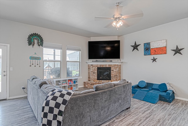 1407 Derrick Ave, Odessa, TX 79765 - living room featuring wood finished floors, a ceiling fan, a fireplace, and baseboards