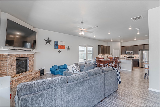1407 Derrick Ave, Odessa, TX 79765 - living room with a fireplace, light wood-style floors, ceiling fan, baseboards, and recessed lighting