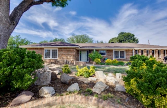 ranch-style home featuring brick siding
