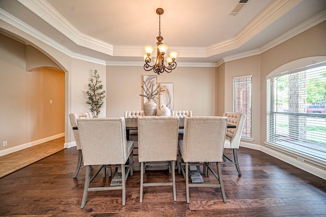 dining room featuring a raised ceiling, ornamental molding, and a chandelier