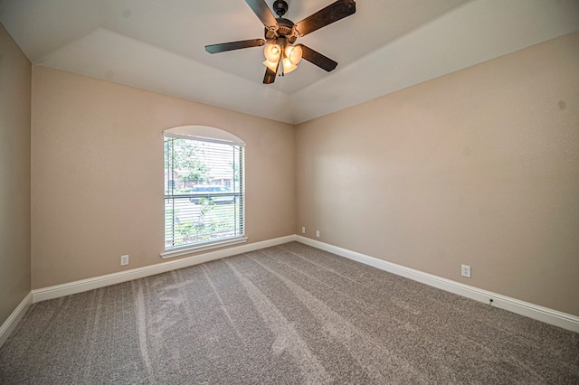 spare room with ceiling fan, a raised ceiling, and carpet floors