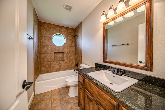 full bathroom featuring vanity, tiled shower / bath combo, and toilet