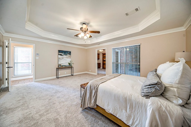 carpeted bedroom featuring a raised ceiling, ceiling fan, and crown molding