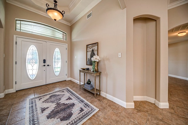 foyer entrance featuring french doors, crown molding, and a tray ceiling