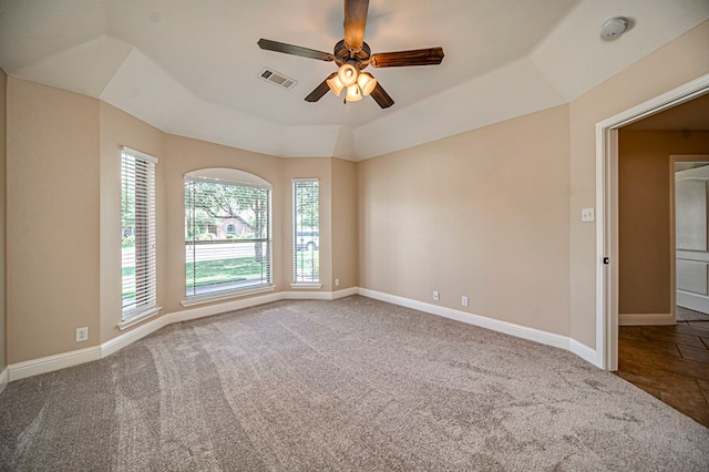 carpeted empty room featuring a raised ceiling and ceiling fan