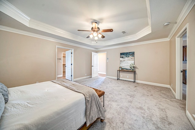 carpeted bedroom with ornamental molding, ceiling fan, and a tray ceiling