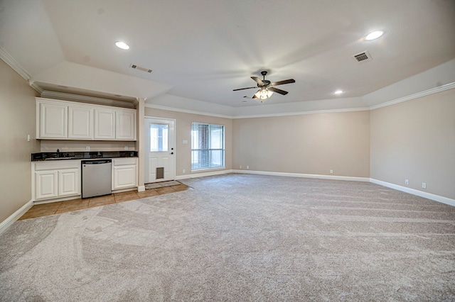 unfurnished living room with sink, ceiling fan, crown molding, and light colored carpet