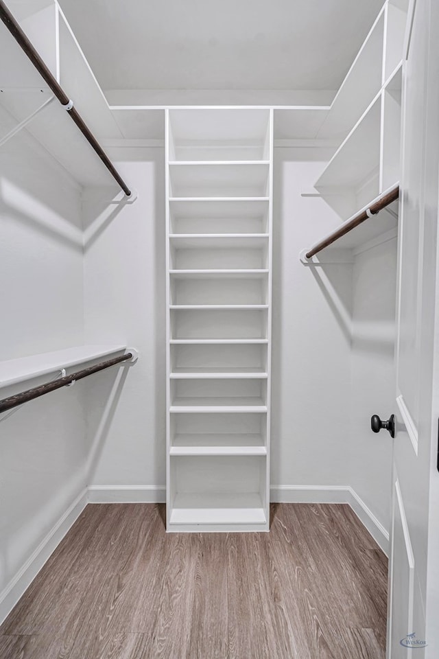 walk in closet with hardwood / wood-style floors