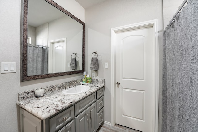 bathroom featuring walk in shower and vanity