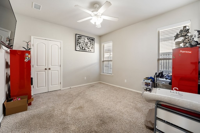 interior space with ceiling fan and carpet flooring