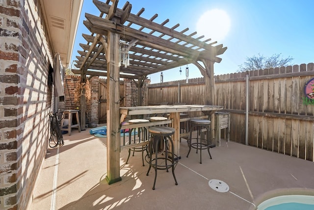 view of patio with exterior bar and a pergola