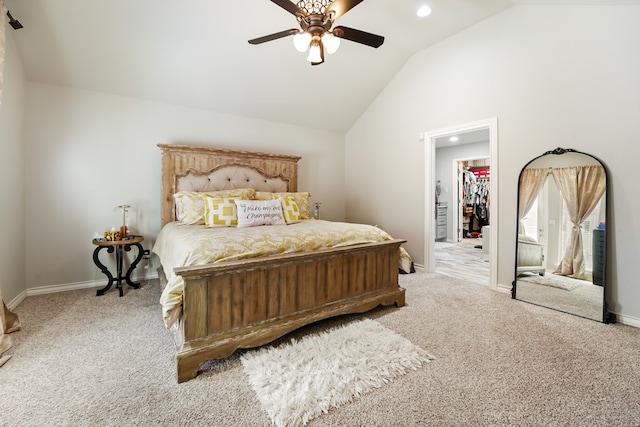 carpeted bedroom featuring a walk in closet, ceiling fan, vaulted ceiling, and a closet