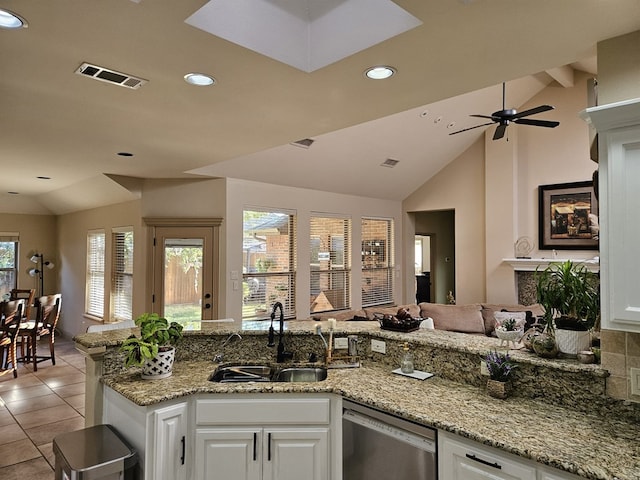 kitchen featuring dishwasher, lofted ceiling, sink, ceiling fan, and white cabinetry