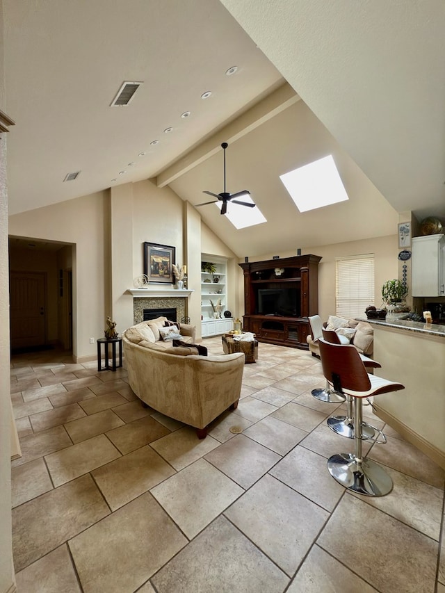 living room with vaulted ceiling with skylight, ceiling fan, and built in features