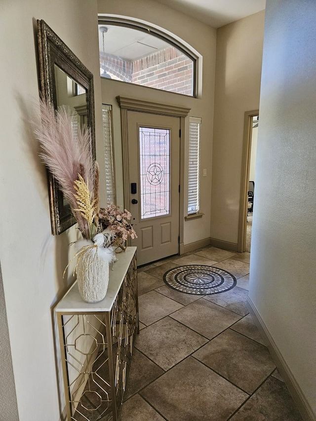 foyer entrance featuring dark tile patterned floors