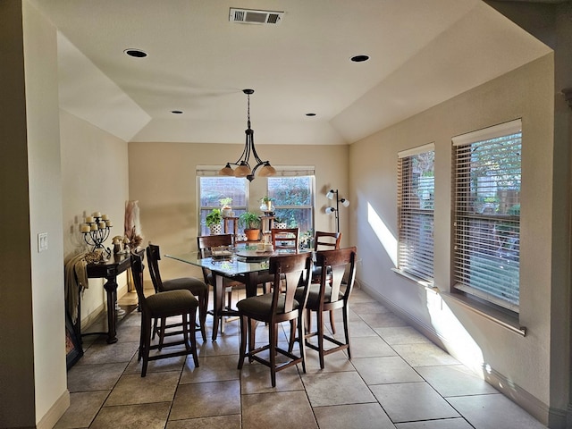 dining room featuring tile patterned floors, vaulted ceiling, and a notable chandelier