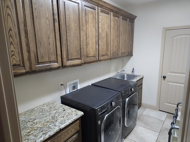 laundry room featuring independent washer and dryer, cabinets, light tile patterned floors, and sink