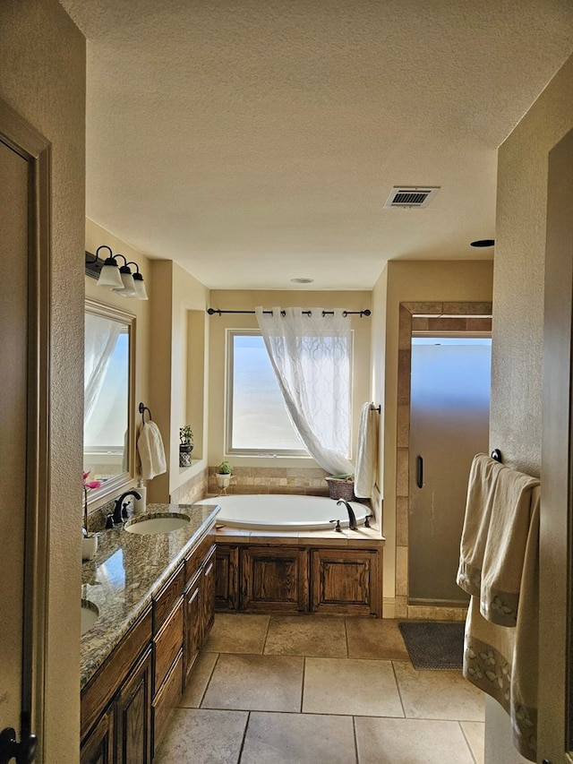 bathroom with tile patterned floors, vanity, a textured ceiling, and shower with separate bathtub