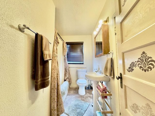 bathroom with a textured ceiling and toilet