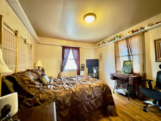 bedroom with hardwood / wood-style floors and a textured ceiling