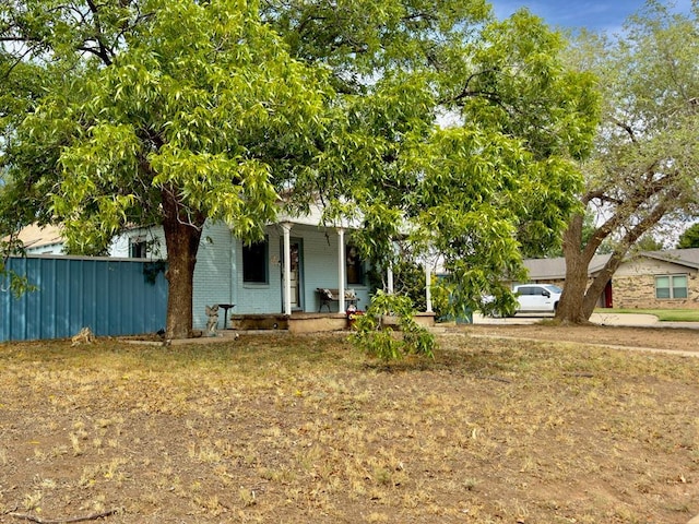 obstructed view of property with covered porch and a front yard