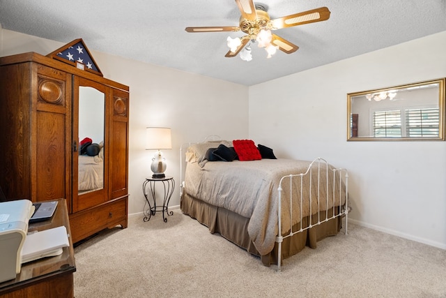 carpeted bedroom with a textured ceiling and ceiling fan