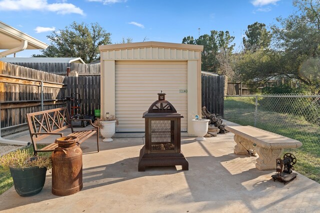 view of patio with a shed and an outdoor fire pit