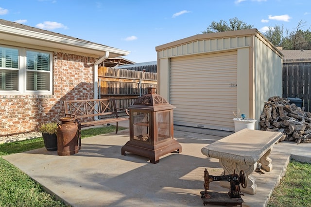 view of patio / terrace featuring a garage, an outdoor fire pit, and an outdoor structure