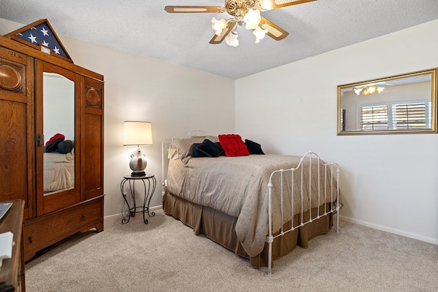 bedroom with a textured ceiling, ceiling fan, and light carpet