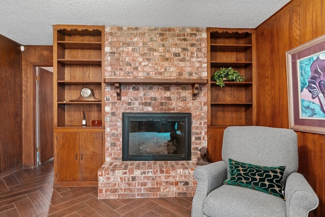2906 Hunters Gln, Big Spring, TX 79720 - living area with a textured ceiling, wooden walls, and a fireplace