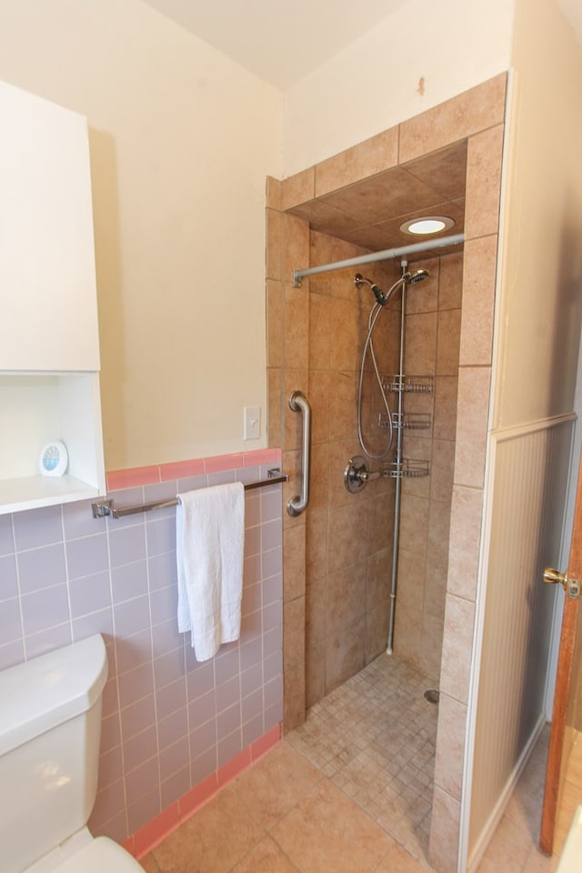 bathroom with toilet, tile walls, and a tile shower