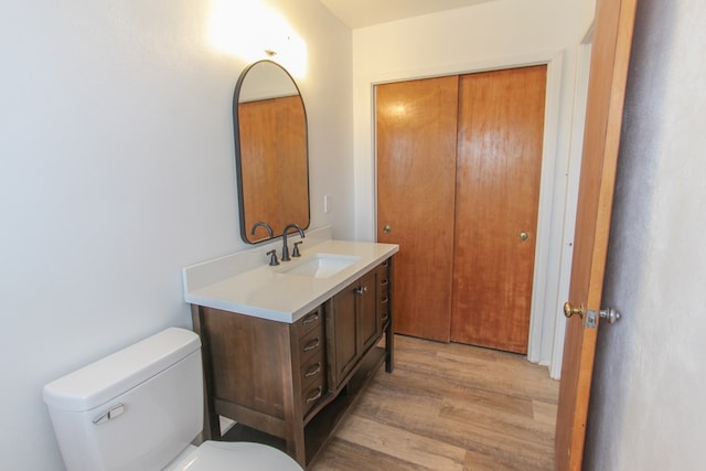 bathroom featuring vanity, wood-type flooring, and toilet