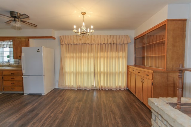 kitchen featuring sink, decorative light fixtures, white refrigerator, dark hardwood / wood-style flooring, and ceiling fan with notable chandelier