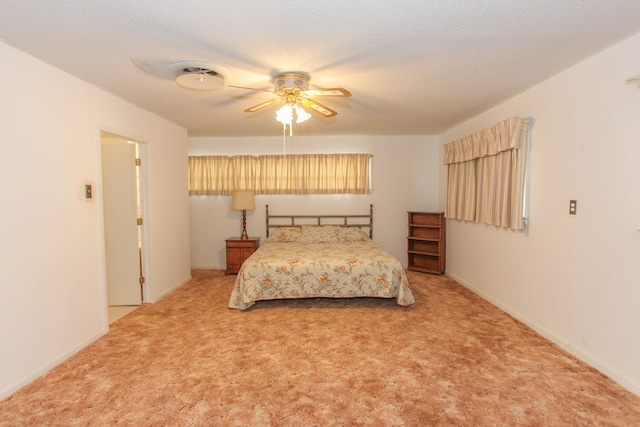 carpeted bedroom with ceiling fan and a textured ceiling