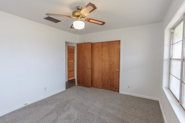 unfurnished bedroom with ceiling fan, a closet, and carpet