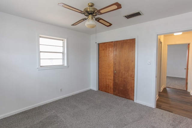 unfurnished bedroom featuring a closet, ceiling fan, and dark colored carpet