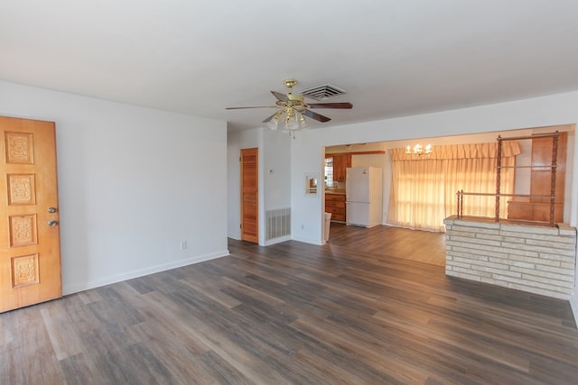 unfurnished living room featuring ceiling fan with notable chandelier and dark hardwood / wood-style floors