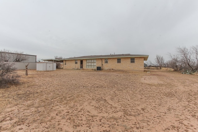 back of house featuring a storage shed