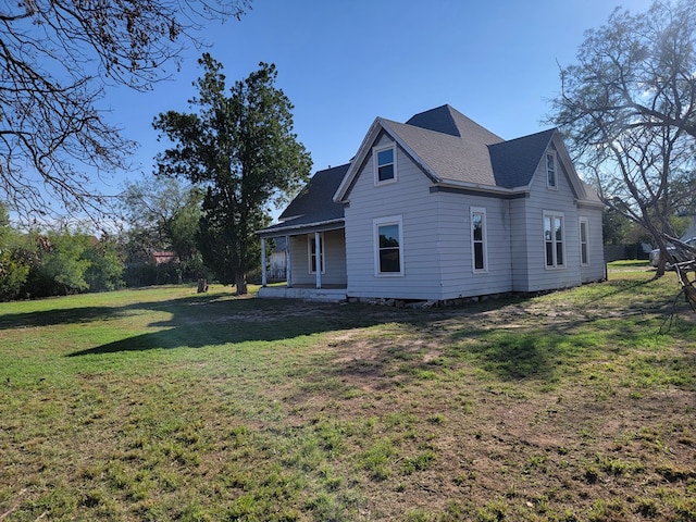 back of house featuring a porch and a lawn