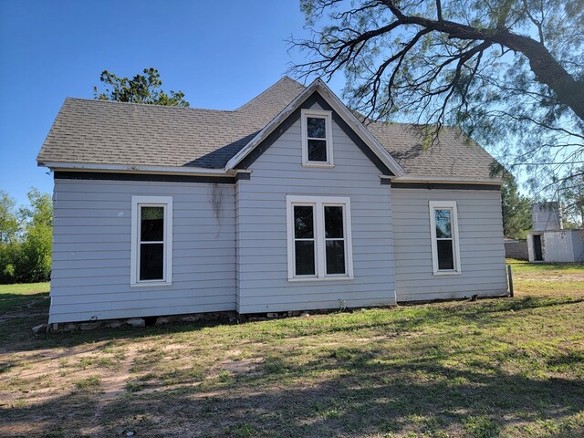 back of property featuring a yard