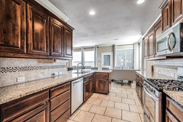 5700 San Miguel Ave, Midland, TX 79705 - kitchen with appliances with stainless steel finishes, a sink, backsplash, crown molding, and dark brown cabinets